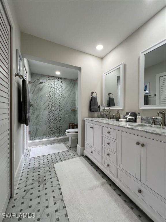 7087 Barrington Cir Unit 201, Naples, FL 34108 - bathroom with toilet, a marble finish shower, double vanity, recessed lighting, and baseboards