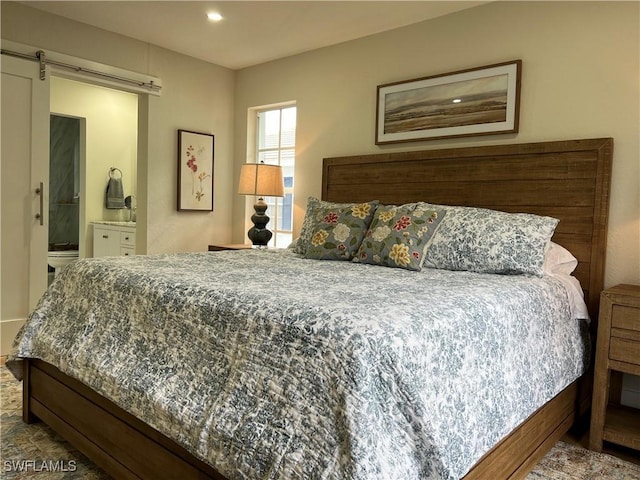 7087 Barrington Cir Unit 201, Naples, FL 34108 - bedroom featuring a barn door, recessed lighting, and ensuite bathroom