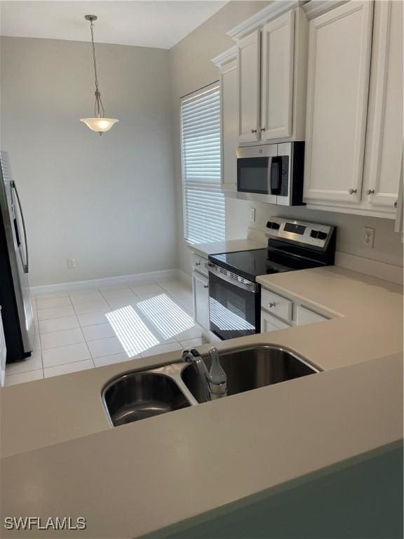 10427 Carolina Willow Dr, Fort Myers, FL 33913 - kitchen featuring appliances with stainless steel finishes, light countertops, light tile patterned flooring, a sink, and pendant lighting