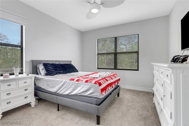 7501 Carnegie Way, Naples, FL 34119 - bedroom with light carpet, multiple windows, ceiling fan, and baseboards