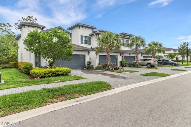 7501 Carnegie Way, Naples, FL 34119 - view of front of house with stucco siding, decorative driveway, and an attached garage
