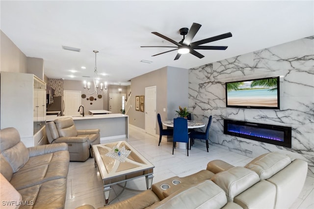 15873 Marcello Cir Unit 76, Naples, FL 34110 - living room with a ceiling fan, a chandelier, a fireplace, and baseboards