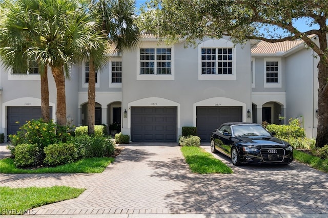 15873 Marcello Cir Unit 76, Naples, FL 34110 - townhome / multi-family property featuring driveway, stucco siding, and a garage