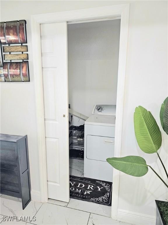 303 E 7th St, Lehigh Acres, FL 33972 - laundry room with washer / dryer and light marble finish flooring
