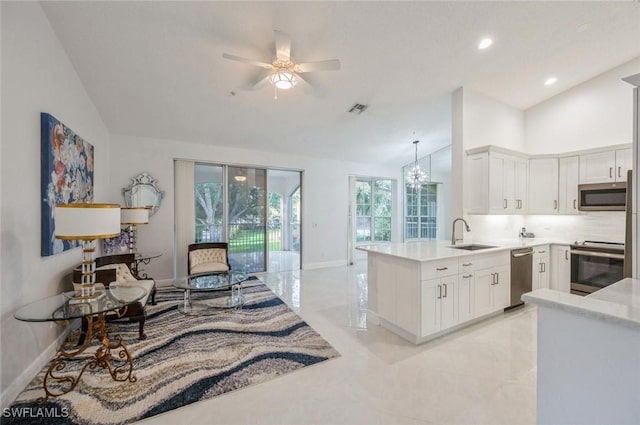 74 Silver Oaks Cir Unit 9-202, Naples, FL 34119 - kitchen with stainless steel appliances, lofted ceiling, a peninsula, light countertops, and baseboards