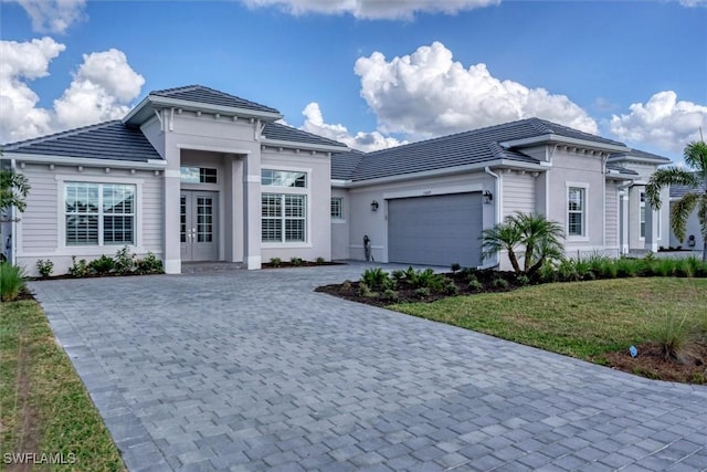 15889 Cranes Marsh Ct, Punta Gorda, FL 33982 - prairie-style house with french doors, a garage, decorative driveway, a front yard, and a tile roof