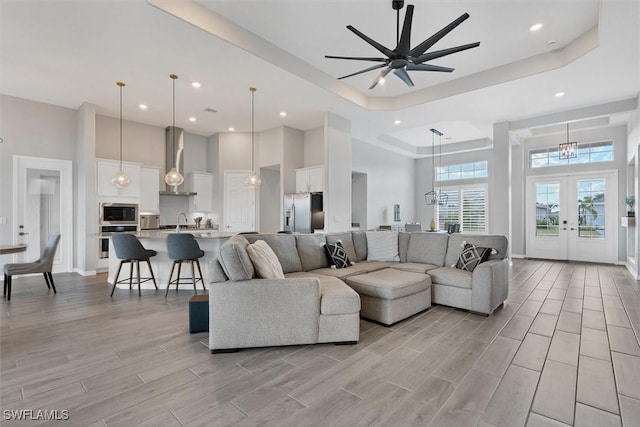 15889 Cranes Marsh Ct, Punta Gorda, FL 33982 - living room featuring a high ceiling, recessed lighting, light wood-style flooring, a raised ceiling, and french doors
