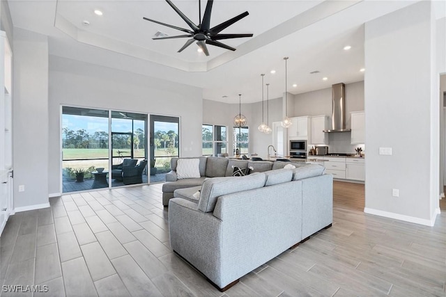 15889 Cranes Marsh Ct, Punta Gorda, FL 33982 - living area with recessed lighting, a ceiling fan, a towering ceiling, a tray ceiling, and baseboards