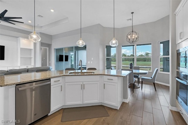 15889 Cranes Marsh Ct, Punta Gorda, FL 33982 - kitchen with stainless steel appliances, a sink, open floor plan, light wood-style flooring, and white cabinets