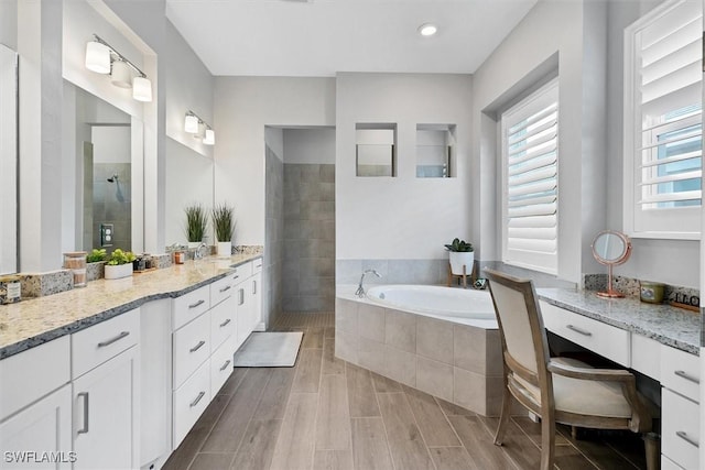 15889 Cranes Marsh Ct, Punta Gorda, FL 33982 - bathroom featuring vanity, tiled shower, a bath, wood finished floors, and recessed lighting