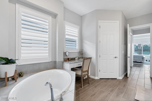 15889 Cranes Marsh Ct, Punta Gorda, FL 33982 - bathroom with a garden tub, wood finished floors, and baseboards