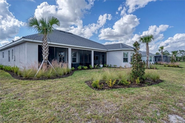 15889 Cranes Marsh Ct, Punta Gorda, FL 33982 - back of house with a lawn, stucco siding, a tiled roof, and a sunroom