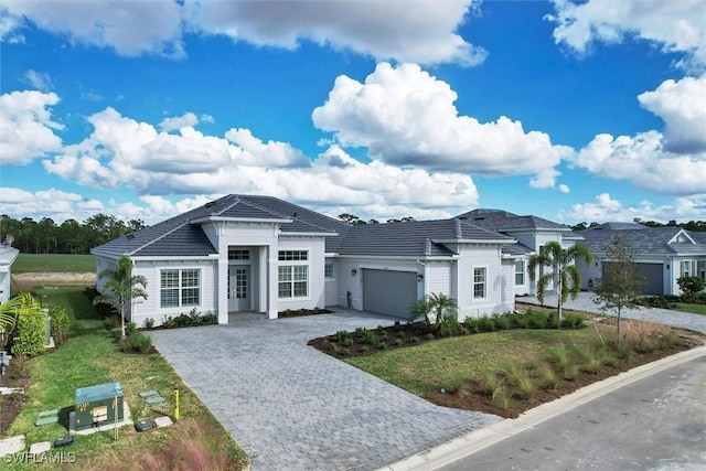 15889 Cranes Marsh Ct, Punta Gorda, FL 33982 - view of front facade featuring a garage, decorative driveway, a tile roof, and a front lawn
