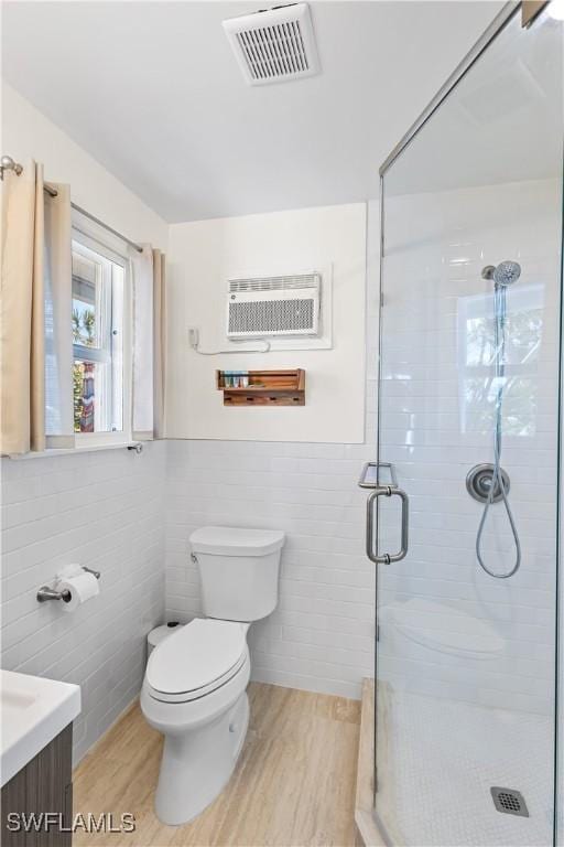 250 Ohio Ave, Fort Myers Beach, FL 33931 - bathroom featuring toilet, tile walls, a stall shower, vanity, and wood finished floors