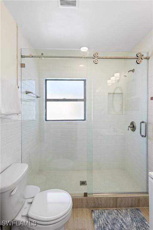 250 Ohio Ave, Fort Myers Beach, FL 33931 - full bathroom featuring toilet, a stall shower, wood finished floors, and tile walls