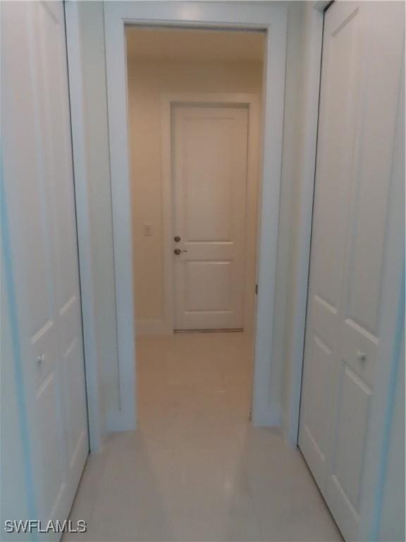 4132 64th Ave NE, Naples, FL 34120 - hallway with light tile patterned floors and baseboards