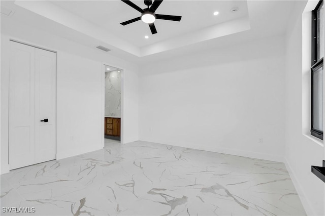 331 Naples Ave S, Lehigh Acres, FL 33974 - unfurnished bedroom with marble finish flooring, a raised ceiling, recessed lighting, ensuite bath, and a ceiling fan