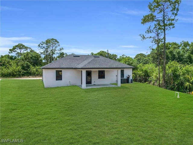 331 Naples Ave S, Lehigh Acres, FL 33974 - back of property with a patio area, a lawn, stucco siding, a shingled roof, and cooling unit