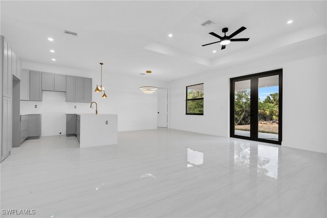 331 Naples Ave S, Lehigh Acres, FL 33974 - unfurnished living room with recessed lighting, a sink, a ceiling fan, and a raised ceiling