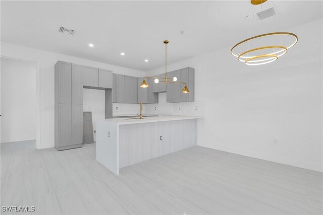 331 Naples Ave S, Lehigh Acres, FL 33974 - kitchen featuring gray cabinets, a peninsula, light countertops, pendant lighting, and recessed lighting