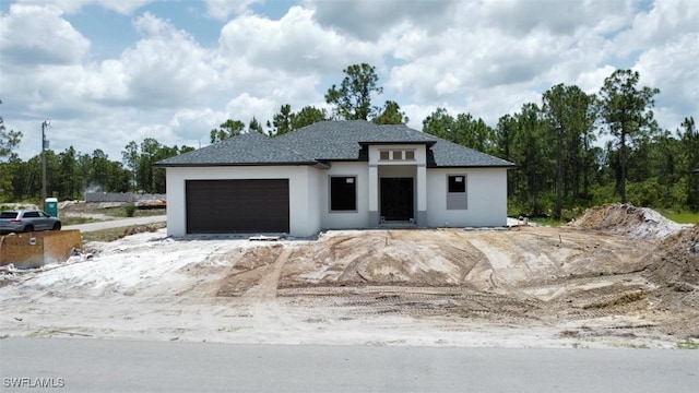 1601 W 9th St, Lehigh Acres, FL 33972 - prairie-style house with stucco siding, an attached garage, and roof with shingles