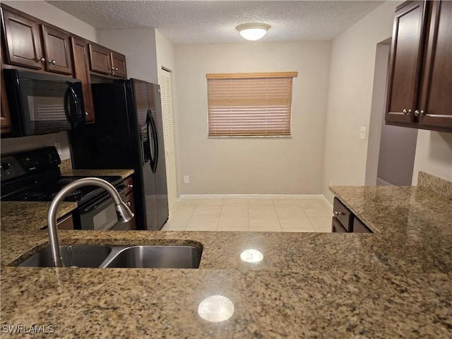 605 Squire Cir Unit 203, Naples, FL 34104 - kitchen with black appliances, light stone counters, a textured ceiling, light tile patterned floors, and dark brown cabinetry