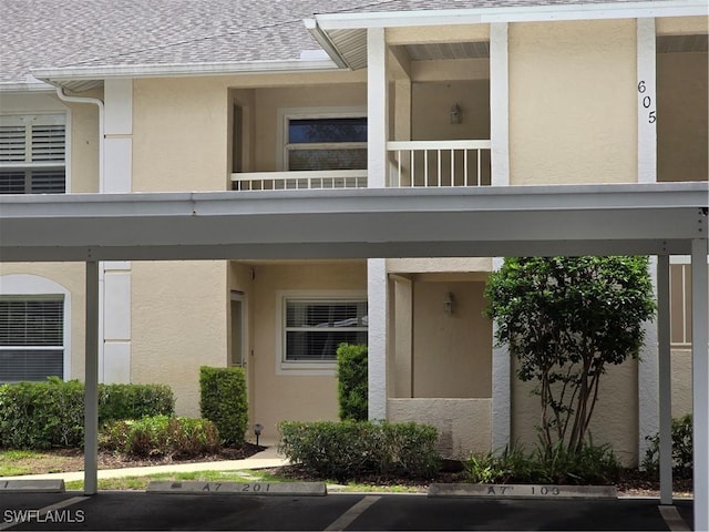 605 Squire Cir Unit 203, Naples, FL 34104 - view of property featuring covered and uncovered parking
