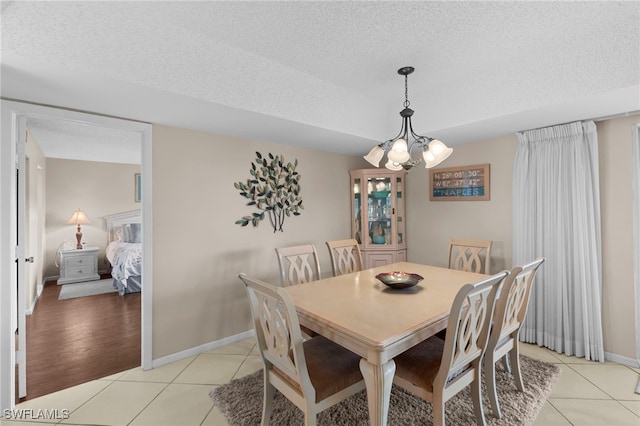 601 Teryl Rd Unit 2262, Naples, FL 34112 - dining room with light tile patterned floors, a textured ceiling, a chandelier, and baseboards