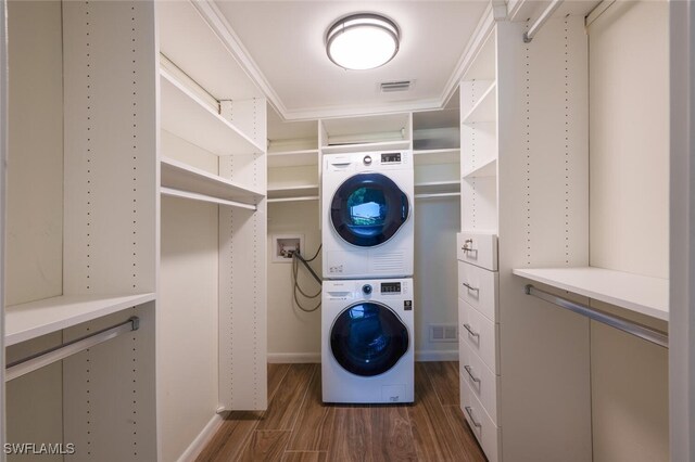 3055 Riviera Dr Unit 306, Naples, FL 34103 - laundry room with stacked washer and clothes dryer, dark wood finished floors, and baseboards