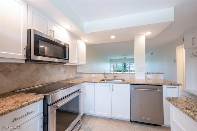 3055 Riviera Dr Unit 306, Naples, FL 34103 - kitchen with appliances with stainless steel finishes, a sink, tasteful backsplash, white cabinets, and recessed lighting
