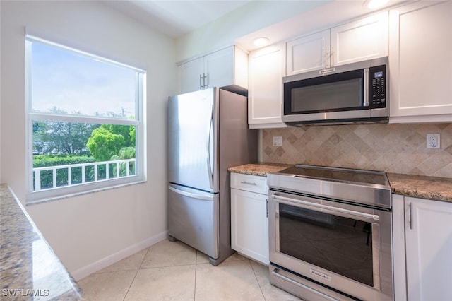 3055 Riviera Dr Unit 306, Naples, FL 34103 - kitchen with appliances with stainless steel finishes, white cabinetry, and decorative backsplash