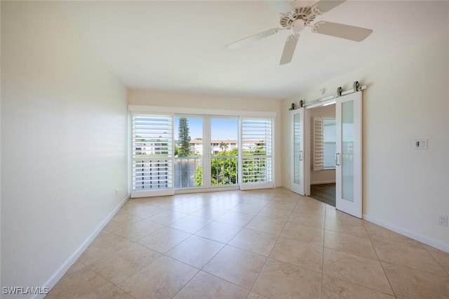3055 Riviera Dr Unit 306, Naples, FL 34103 - spare room featuring baseboards, light tile patterned flooring, a barn door, and ceiling fan