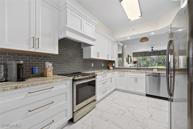 1940 Willow Bend Cir Unit 102, Naples, FL 34109 - kitchen with stainless steel appliances, light marble finish floors, white cabinets, light stone countertops, and decorative backsplash