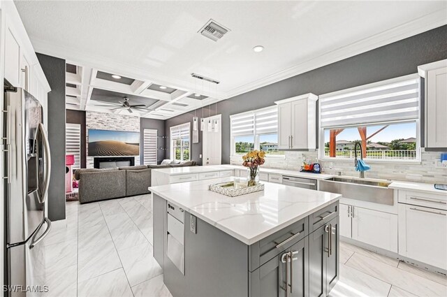 7082 Aliso Ave, West Palm Beach, FL 33413 - kitchen featuring stainless steel appliances, light marble finish floors, gray cabinets, a kitchen island, and coffered ceiling