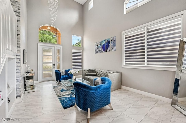 7082 Aliso Ave, West Palm Beach, FL 33413 - living area with marble finish flooring, a high ceiling, and a chandelier