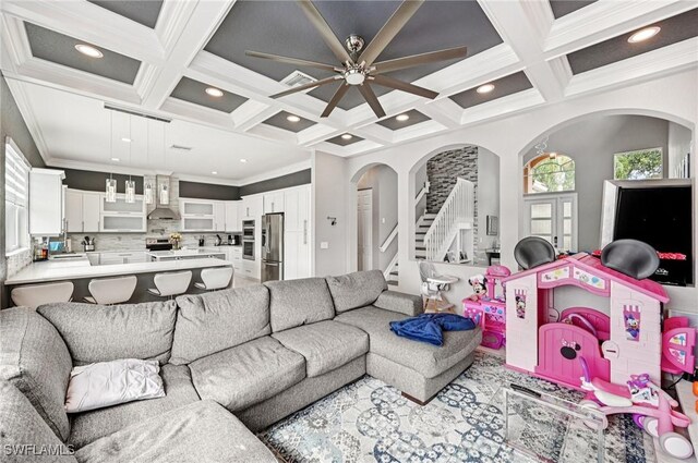 7082 Aliso Ave, West Palm Beach, FL 33413 - living area with coffered ceiling, arched walkways, stairway, ceiling fan, and ornamental molding