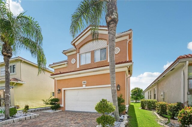 7082 Aliso Ave, West Palm Beach, FL 33413 - view of front of property featuring an attached garage, stucco siding, a tiled roof, and decorative driveway