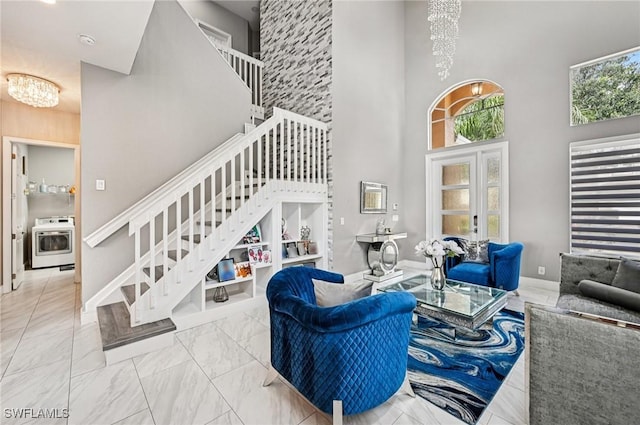 7082 Aliso Ave, West Palm Beach, FL 33413 - living area featuring a chandelier, a towering ceiling, stairs, and marble look tiles