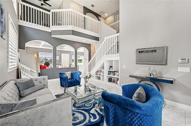 7082 Aliso Ave, West Palm Beach, FL 33413 - living room with marble finish floors, stairs, a high ceiling, and a ceiling fan