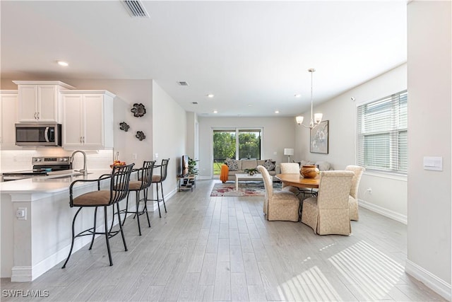 1050 Enbrook Loop, Naples, FL 34114 - dining space with light wood-style floors, recessed lighting, baseboards, and a chandelier