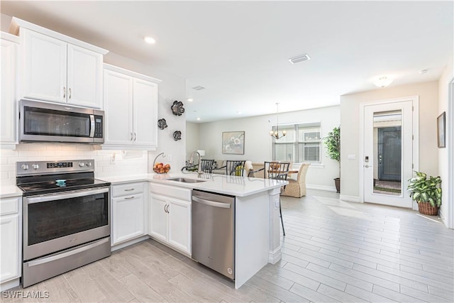 1050 Enbrook Loop, Naples, FL 34114 - kitchen featuring stainless steel appliances, a sink, light countertops, backsplash, and white cabinetry