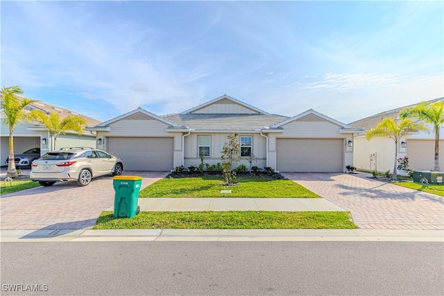 1050 Enbrook Loop, Naples, FL 34114 - single story home featuring decorative driveway, an attached garage, a tile roof, stucco siding, and a front yard