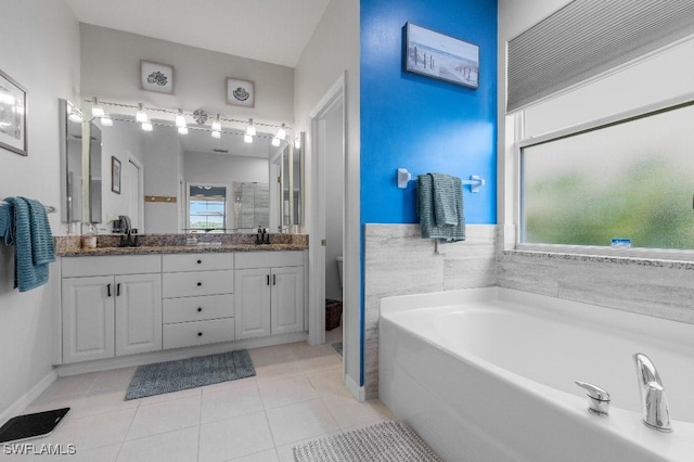 12455 Muddy Creek Ln, Fort Myers, FL 33913 - bathroom featuring a garden tub, double vanity, tile patterned flooring, and toilet