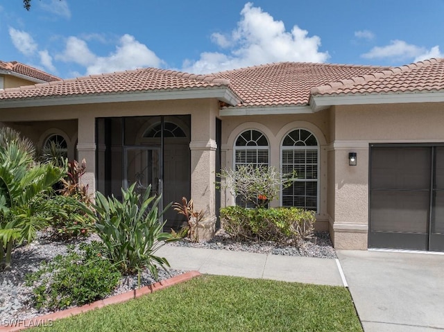 12455 Muddy Creek Ln, Fort Myers, FL 33913 - entrance to property with stucco siding, an attached garage, and a tiled roof
