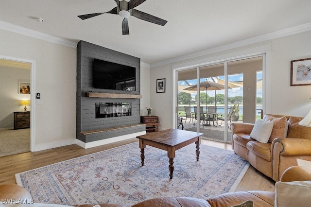 12455 Muddy Creek Ln, Fort Myers, FL 33913 - living room with ornamental molding, a large fireplace, ceiling fan, wood finished floors, and baseboards