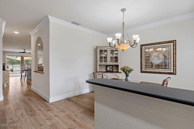 12455 Muddy Creek Ln, Fort Myers, FL 33913 - dining area with a chandelier, light wood-style flooring, baseboards, crown molding, and arched walkways