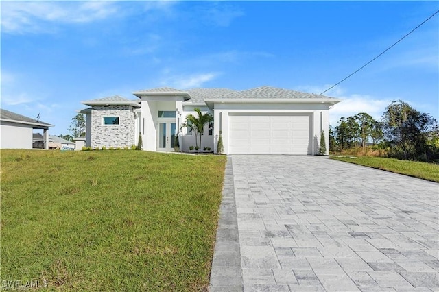 837 Grant Blvd, Lehigh Acres, FL 33974 - prairie-style home with decorative driveway, a front yard, a garage, french doors, and stucco siding