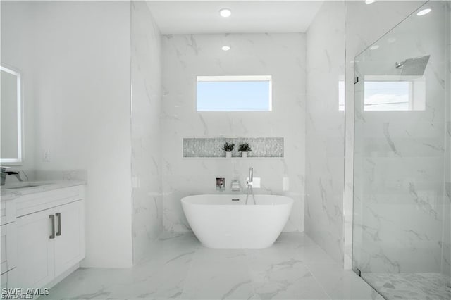 837 Grant Blvd, Lehigh Acres, FL 33974 - bathroom with marble tiled floors, a marble finish shower, vanity, and a soaking tub