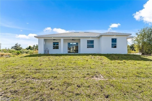 837 Grant Blvd, Lehigh Acres, FL 33974 - rear view of house featuring ceiling fan, a yard, and stucco siding