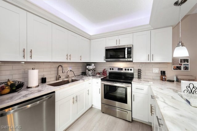 5249 Cedarbend Dr Unit 2, Fort Myers, FL 33919 - kitchen featuring appliances with stainless steel finishes, a sink, a raised ceiling, and white cabinetry